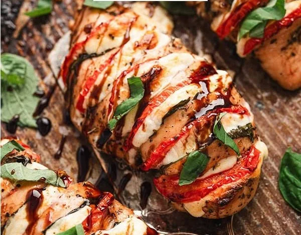 Caprese stuffed chicken with mozzarella, tomatoes, and basil on a plate