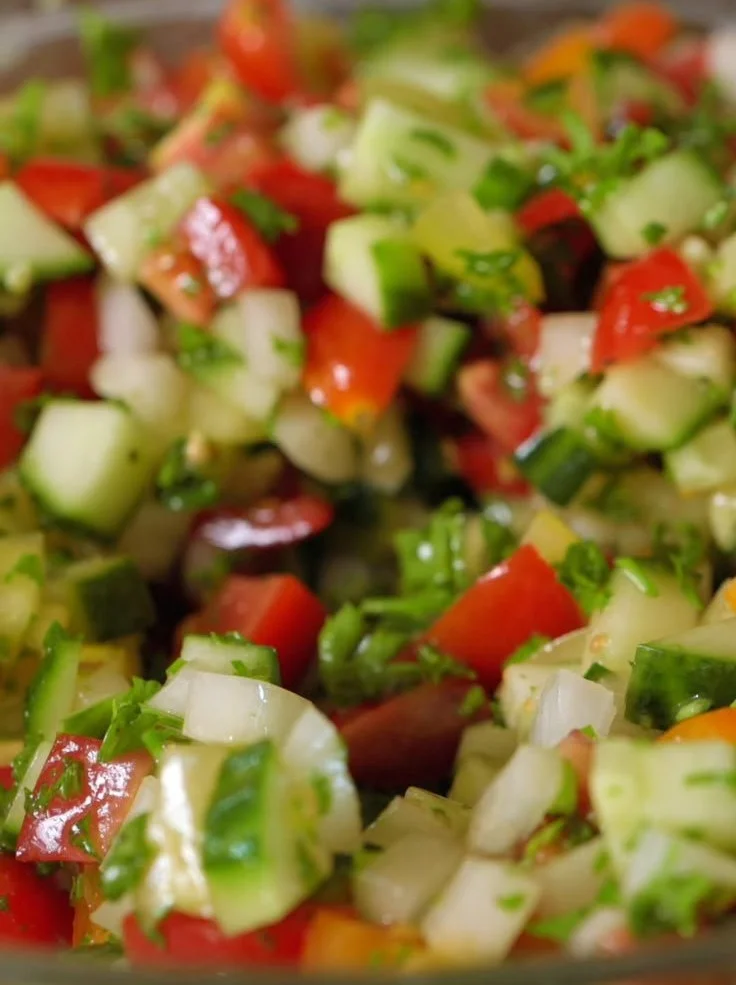 A vibrant and colorful chopped salad with fresh vegetables and herbs