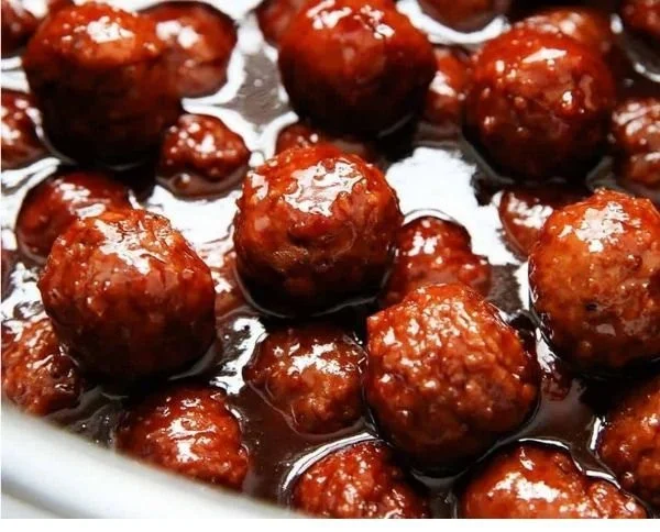 Delicious cranberry meatballs served on a platter with garnishes.
