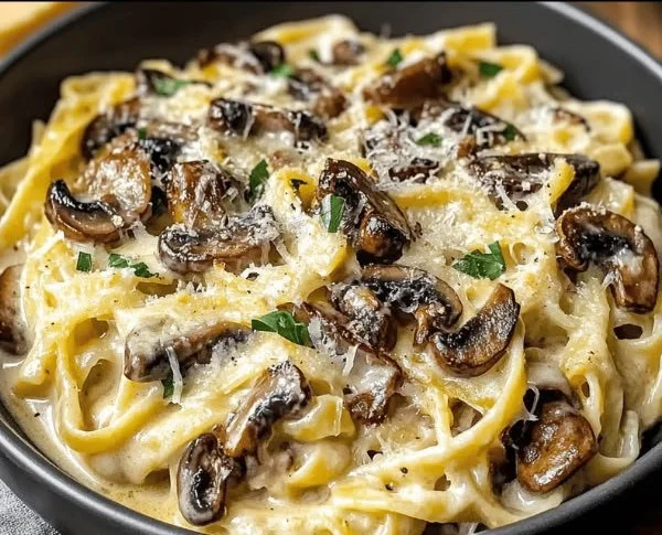 Creamy mushroom gruyere pasta topped with fresh herbs in a stylish bowl