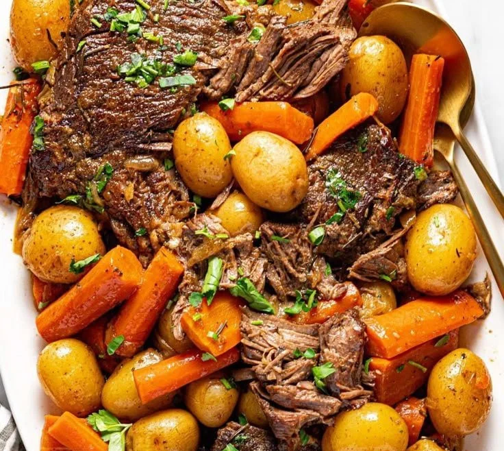 Deliciously cooked Crock Pot pot roast with vegetables on a wooden table