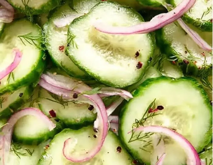 Fresh cucumber salad with vegetables and dressing on a plate
