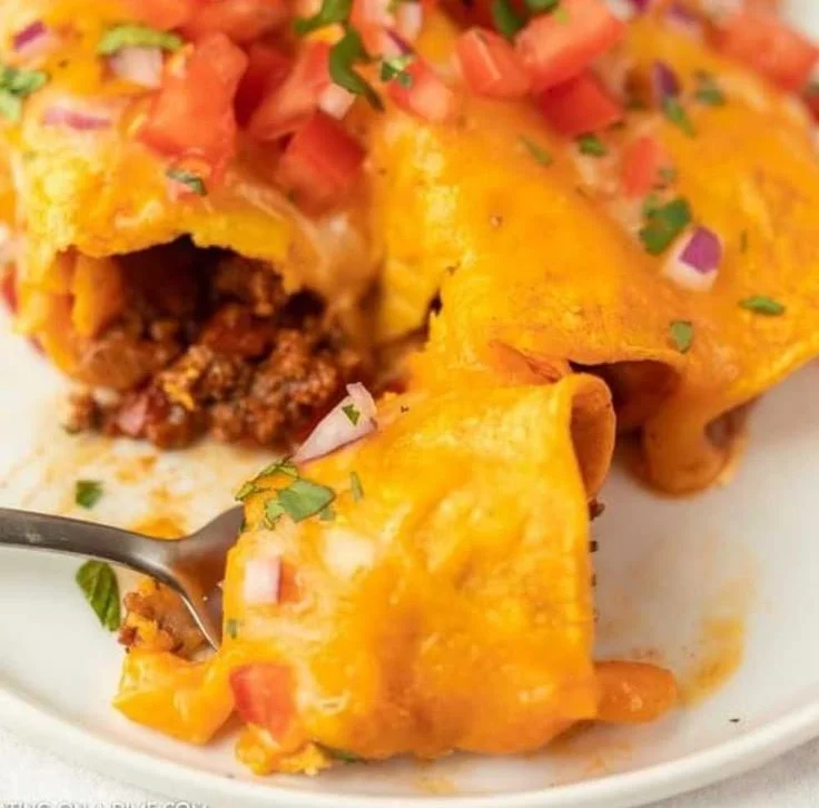 Delicious easy ground beef enchiladas topped with cheese and salsa