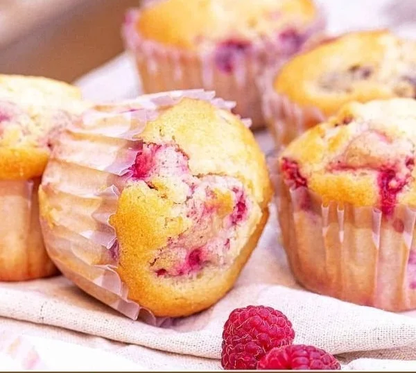 Freshly baked Lemon Raspberry Muffins on a wooden table