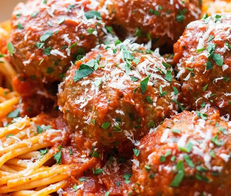Oven-baked Italian meatballs served on a plate with marinara sauce.