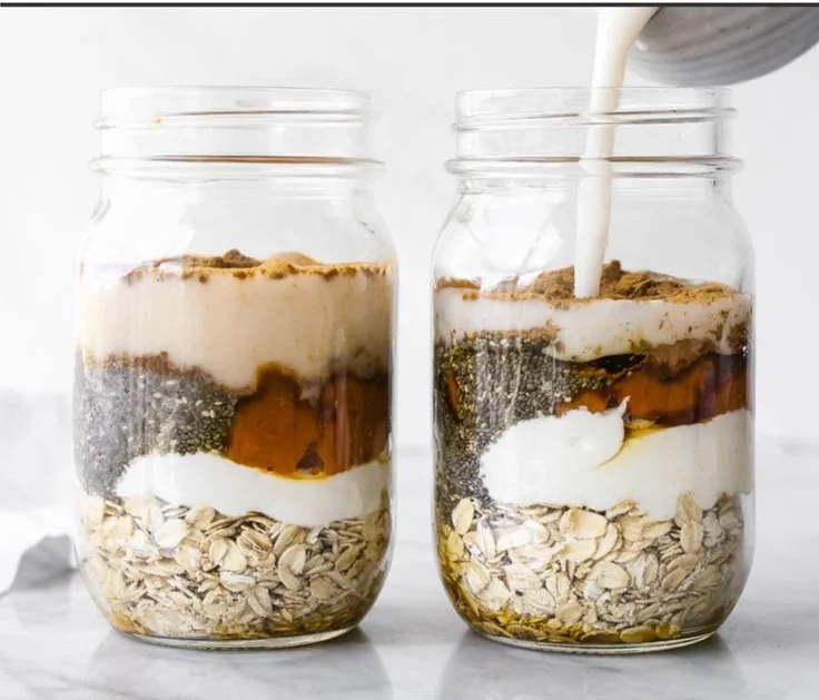 Bowl of pumpkin pie overnight oats topped with whipped cream and spices