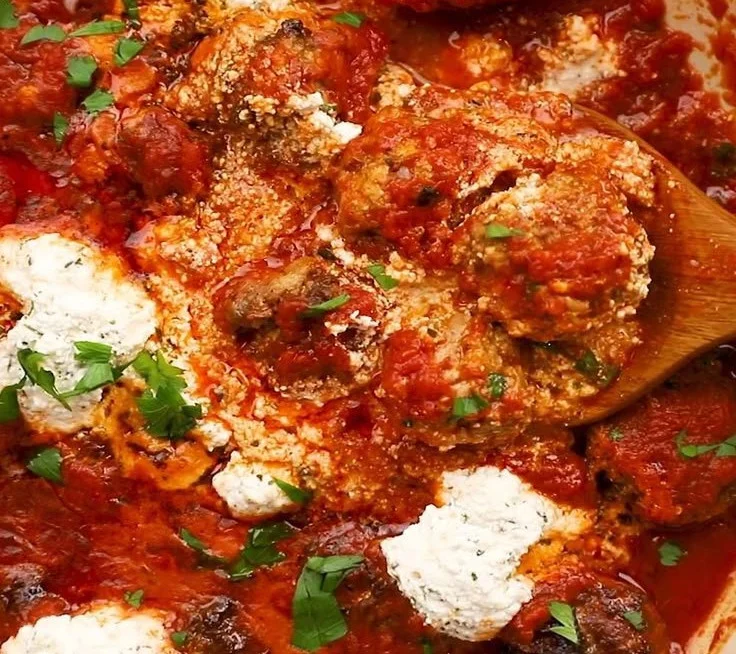 Delicious ricotta meatballs served with marinara sauce and herbs