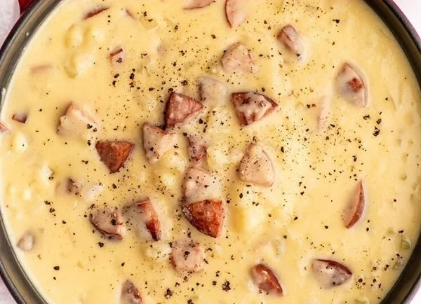 Bowl of hearty sausage potato soup with vegetables and herbs