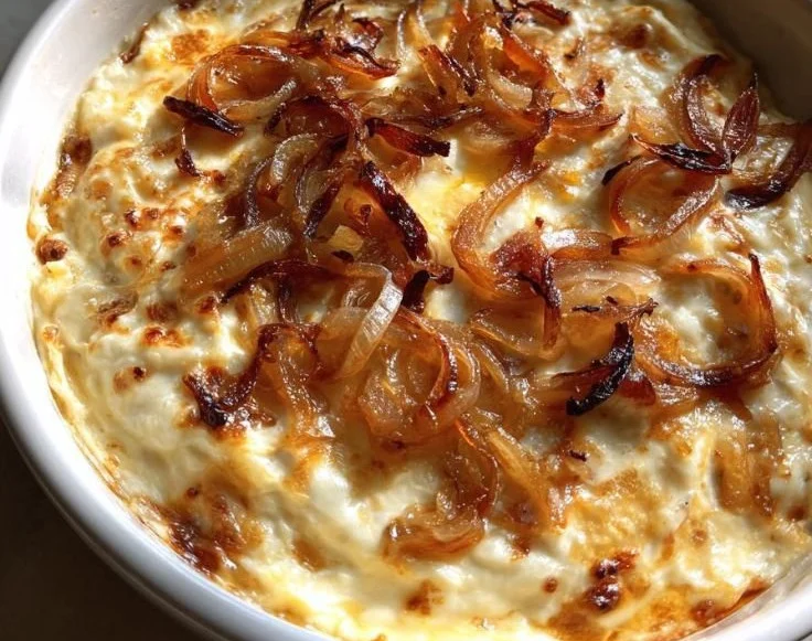 Creamy smoked gouda and onion dip served in a bowl with crackers