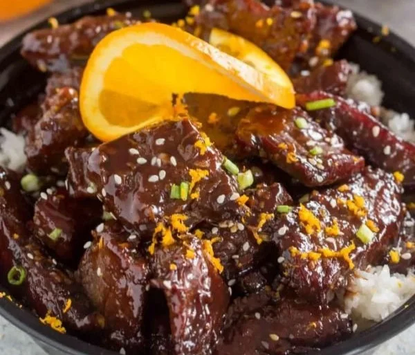 Delicious serving of sticky orange beef with vibrant orange sauce