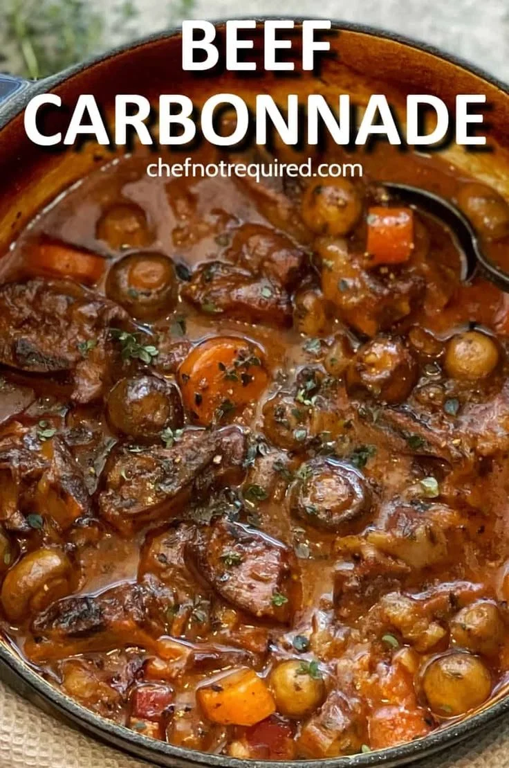 Delicious Beef Carbonnade stew served in a bowl with herbs and bread.