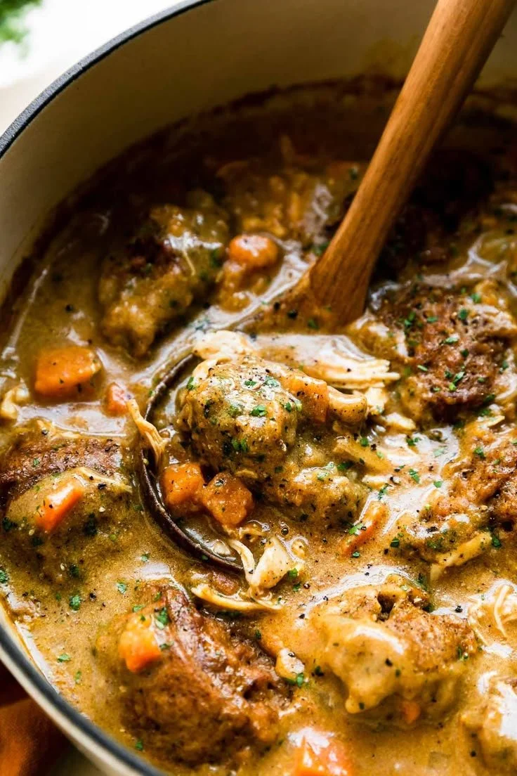 Plate of chicken and pumpkin dumplings garnished with herbs.