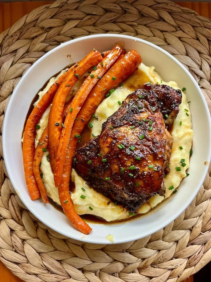 Honey balsamic chicken thighs served with goat cheese mashed potatoes and roasted carrots