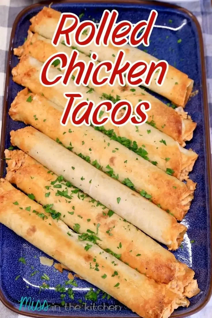Rolled chicken tacos topped with fresh ingredients and served on a plate